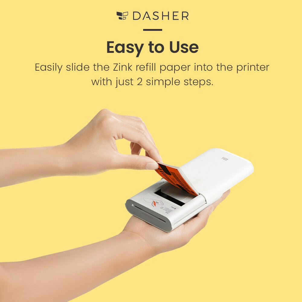 Hands sliding ZINK photo paper into a pocket photo printer