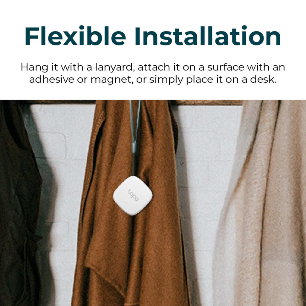 White Tapo temperature & humidity monitor attached to a curtain fabric