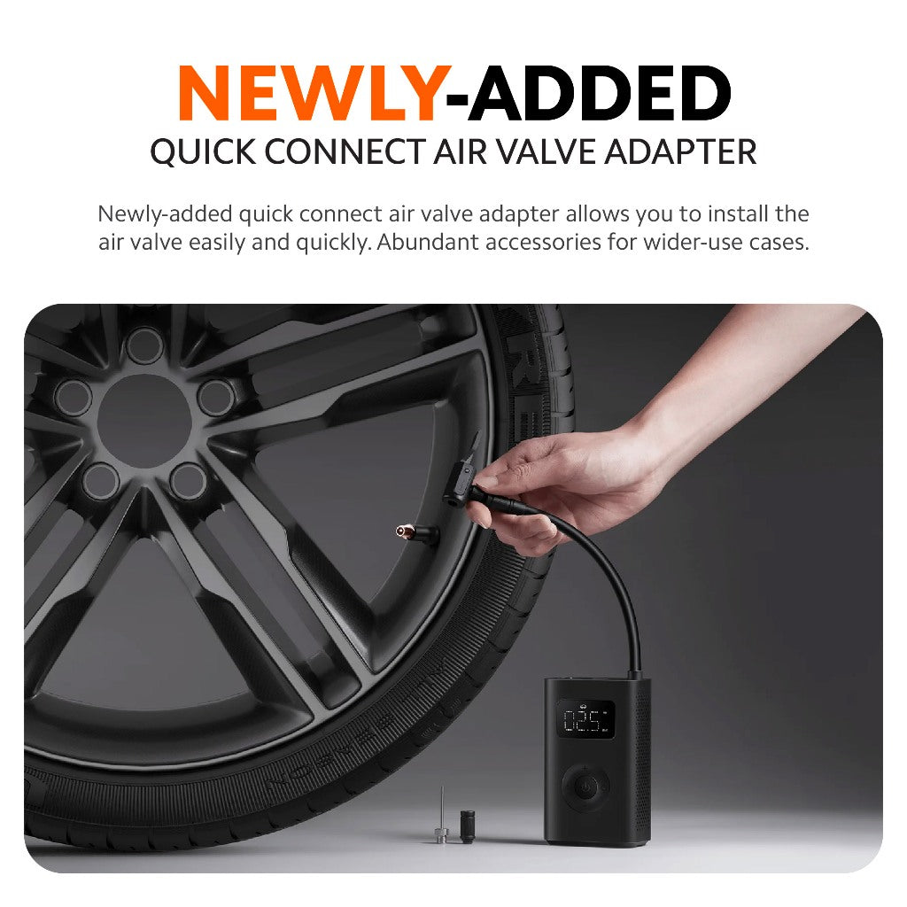 Air compressor with quick-connect valve adapter and nozzle, held beside tire