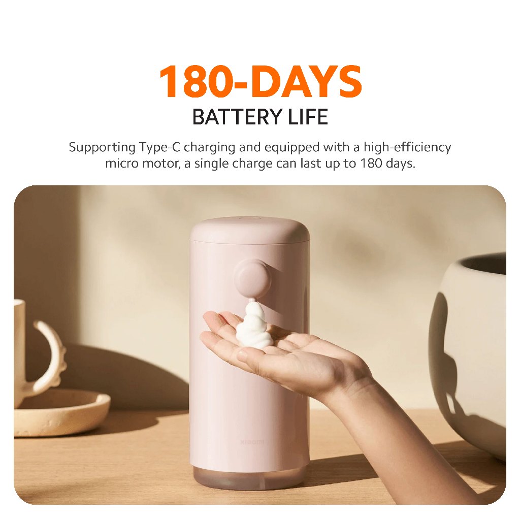 Pink automatic soap dispenser with hand reaching near sensor for lather