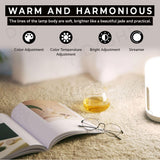 White bedside lamp with warm glow on a carpet near an open book