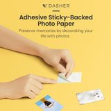 Sticky-backed photo paper being placed by hands
