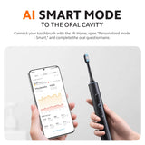 Dark grey smart electric toothbrush in hand, with smartphone app display