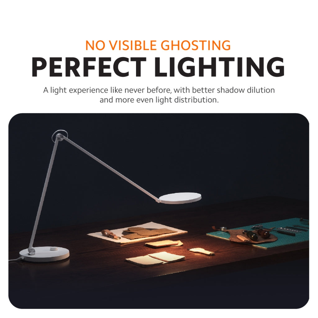 LED desk lamp with extended arms and round base, illuminating a workspace evenly