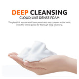 Hand holding dense white foam, automatic soap dispenser dispensing