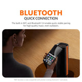 Black Bluetooth speaker with orange trim next to a smartphone for quick connection