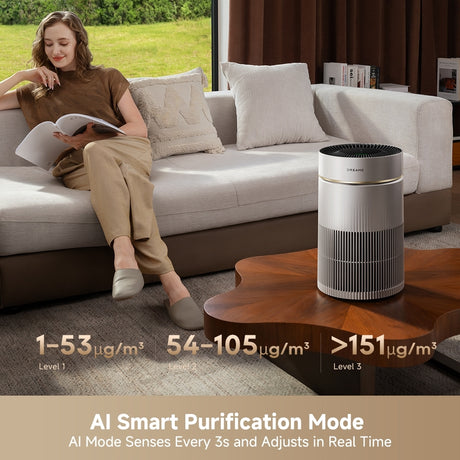 Desktop air purifier on wooden table in living room, white body and dark top grille.