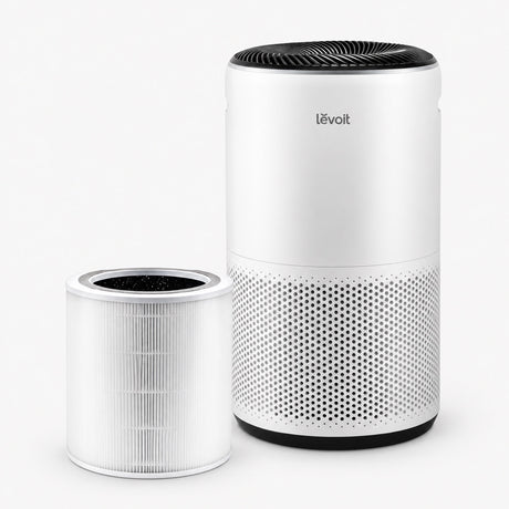 White air purifier with top grille and perforated side panel; spare filter cartridge included