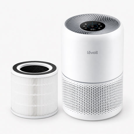 White Levoit air purifier with top control panel and extra replacement filter